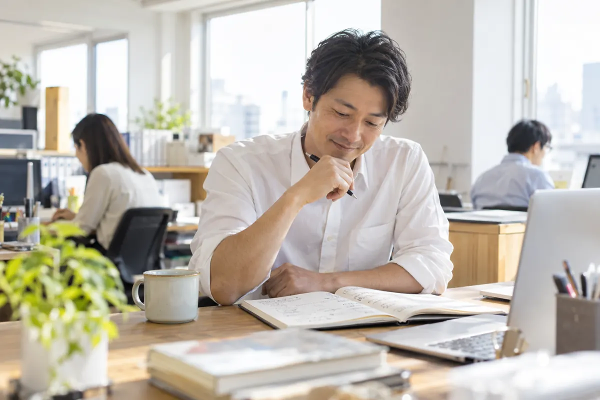 ノートにアイデアを書く経営者